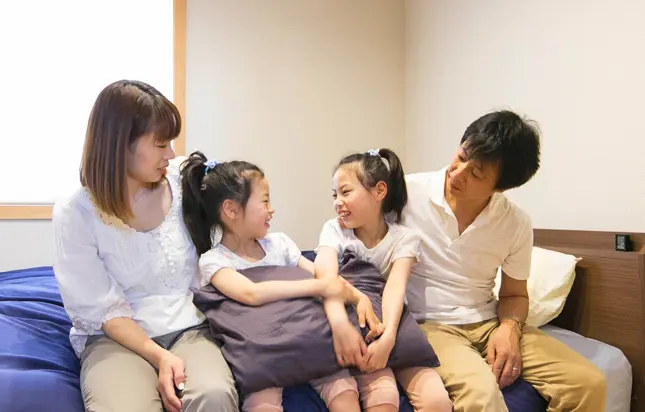 家族がベッドでくつろぐ様子